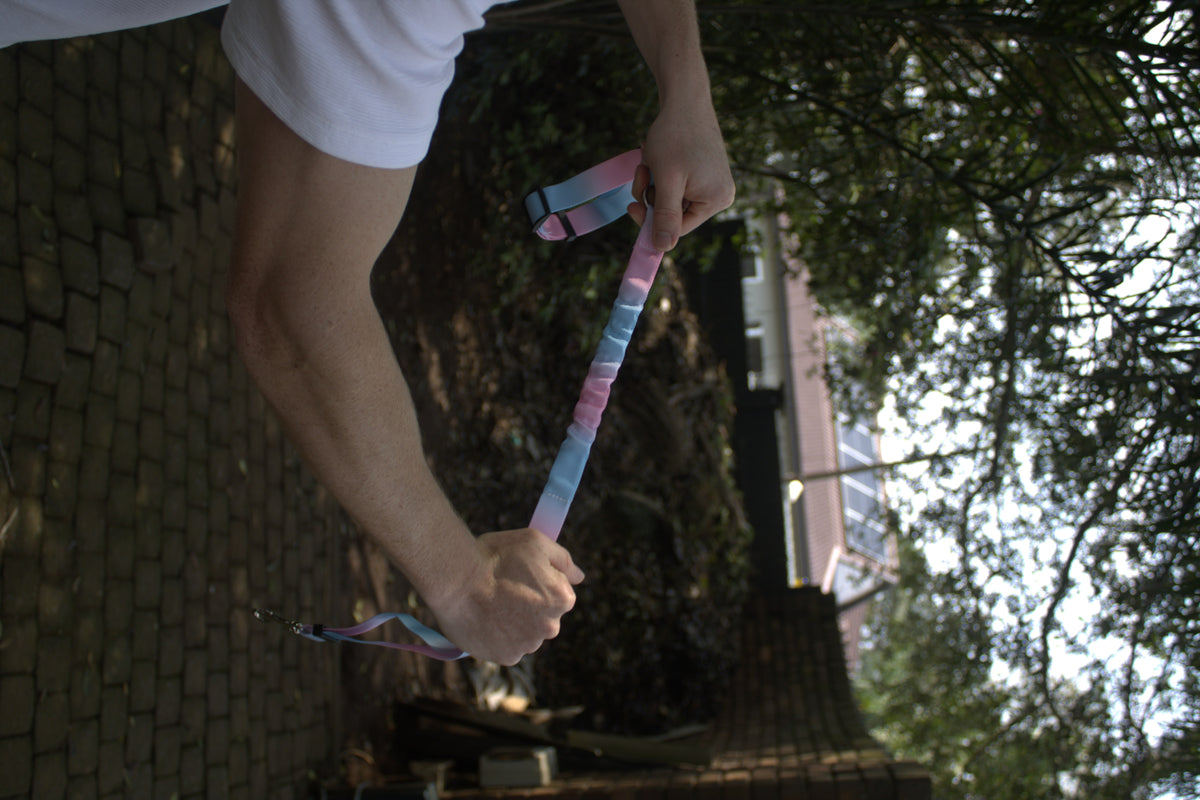 The multi-colour BucklePup bungee section held between two hands under tension.